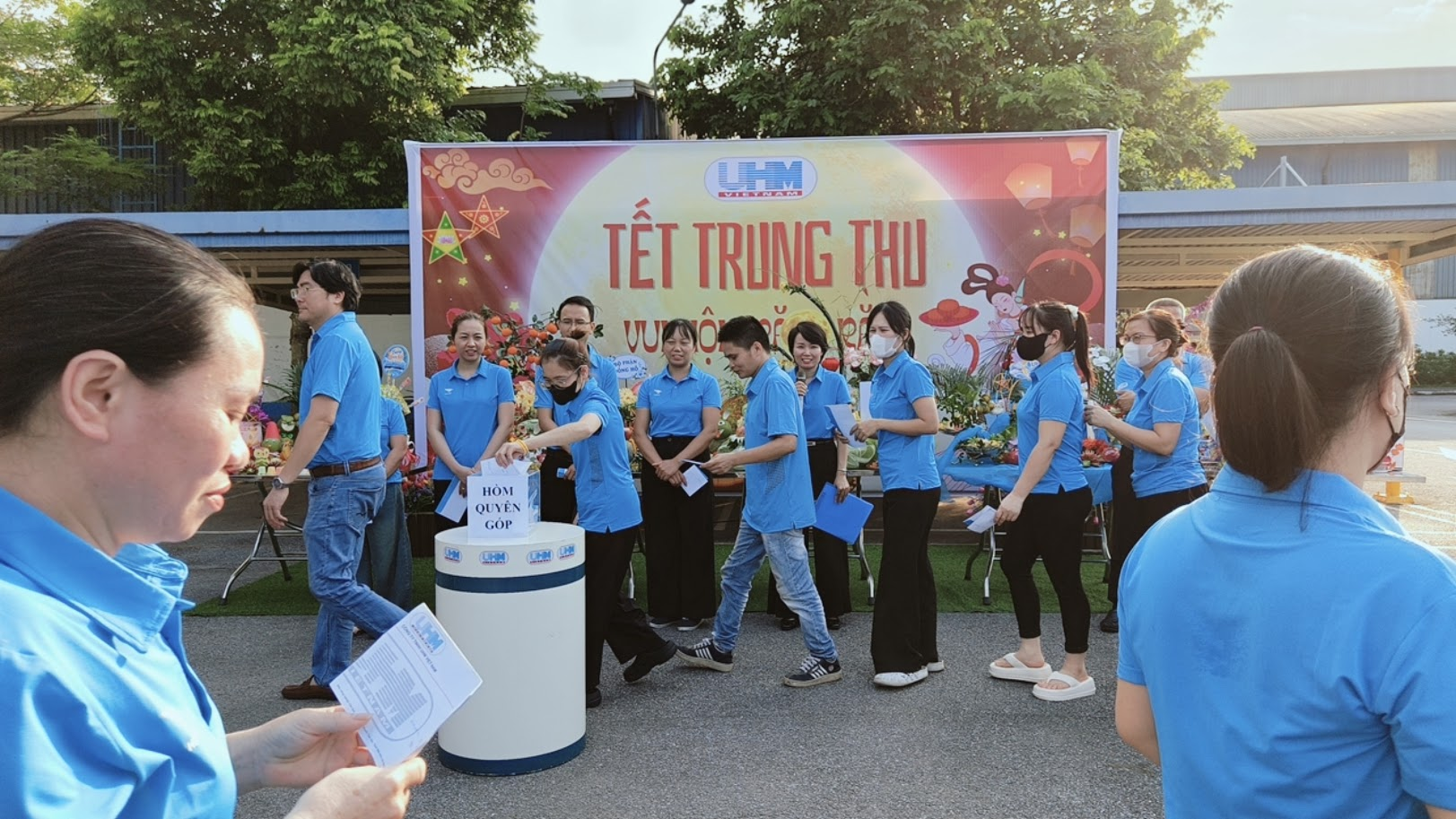 Nhân viên UHM xếp hàng đóng góp tại hòm quyên góp thiện nguyện